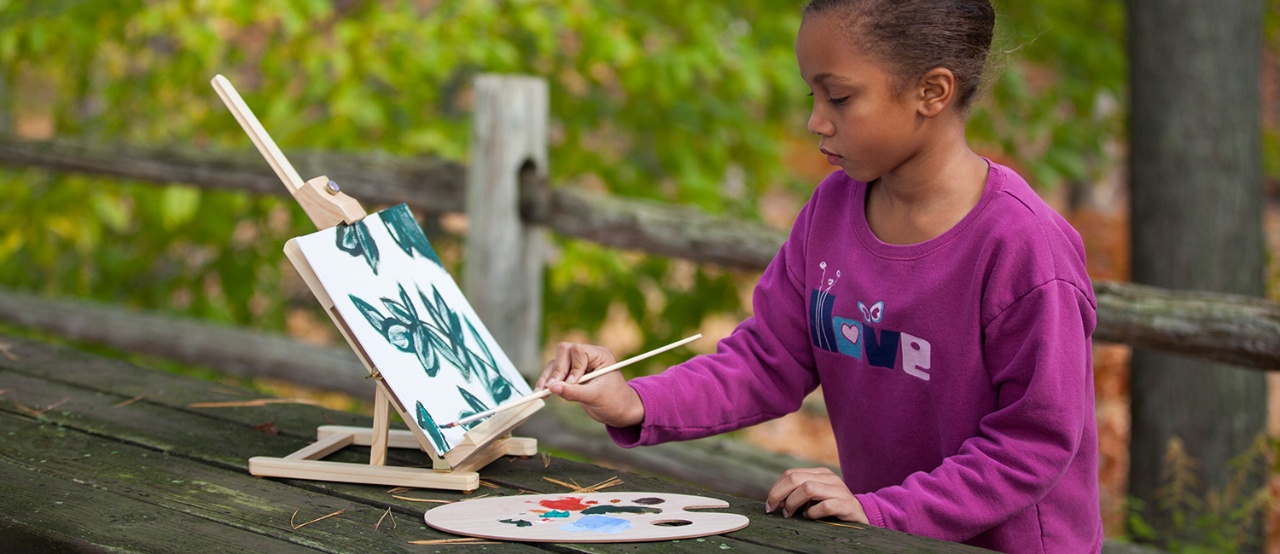  Young girl painting outside. 
